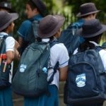 Photo of primary school students with backpacks and hats
